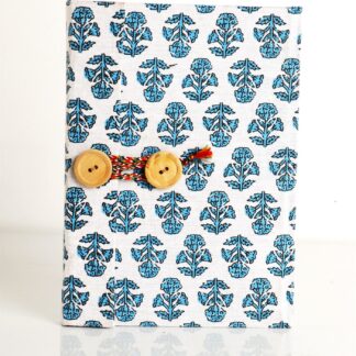Handmade diary with blue pattern fabric overlapping cover and wooden button closure
